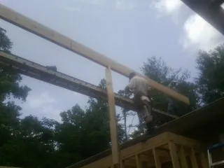 Carpenter setting a ridge beam over a new addition frame — Ice Dam Removal by Roofing Brothers in Trumansburg