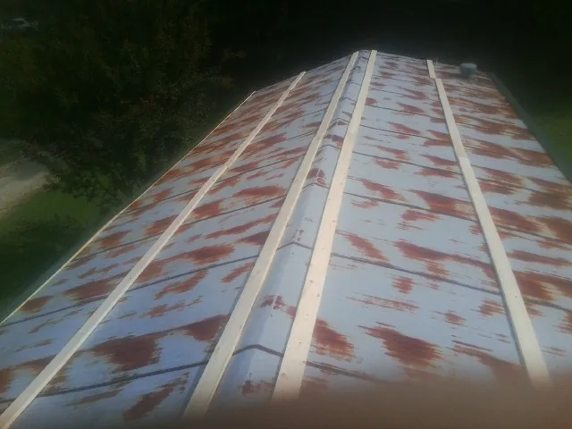 Rusted metal roof panels with new wood purlins before replacement — Storm Damage Roof Repair in Trumansburg by Roofing Brothers