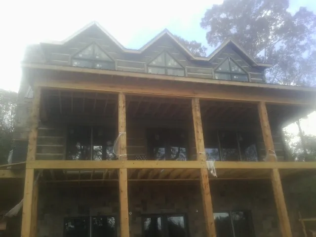 Dormers and porch framing on a large log home under construction — Roof Coating work by our crew in Trumansburg