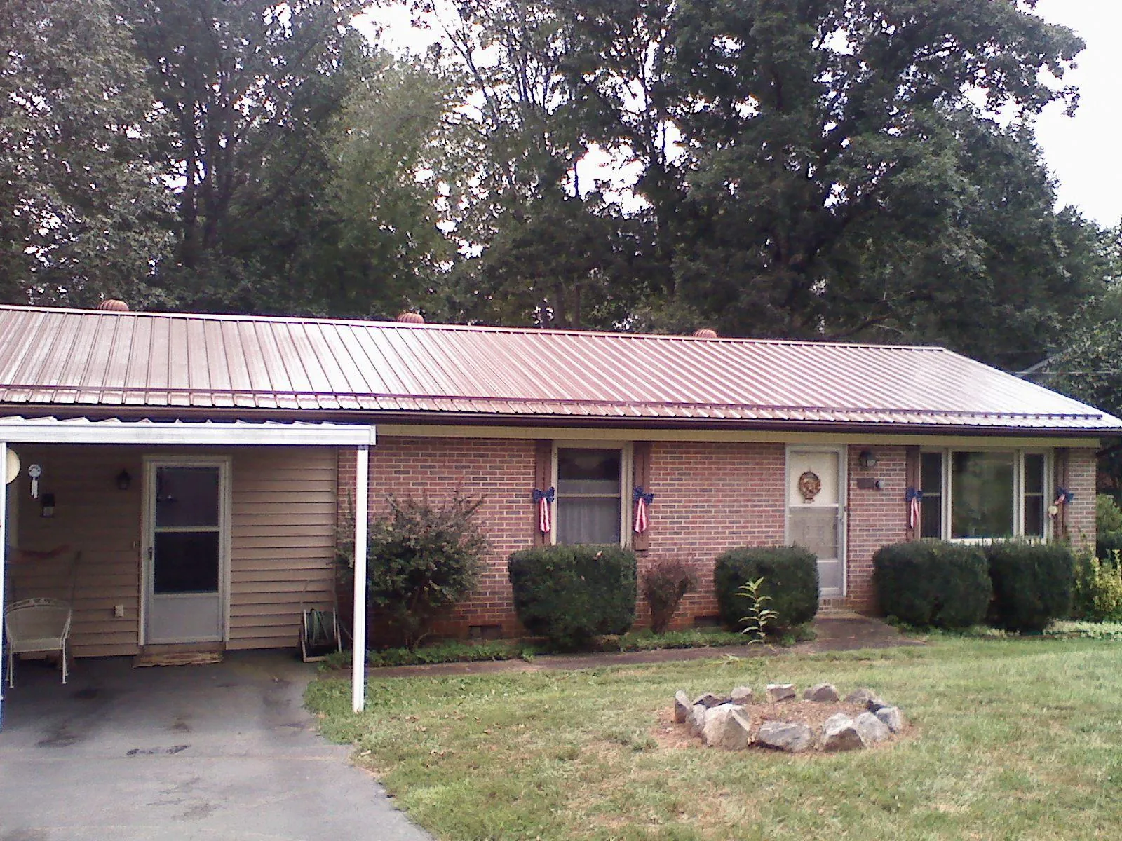 Bronze metal roof and carport on a brick ranch home — Roof Repair work by our crew in Trumansburg